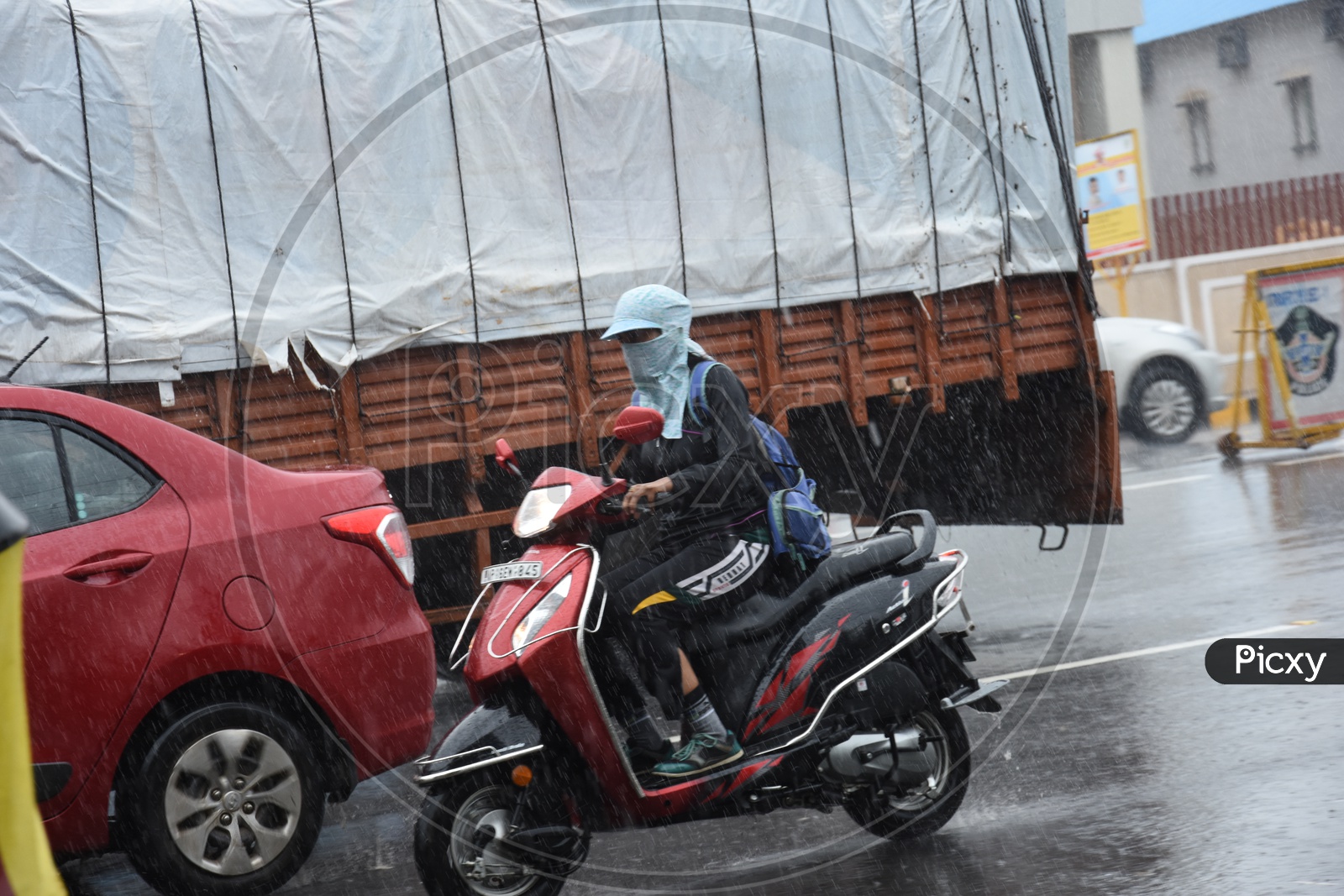 A Two Wheeler Commuter without Helmet driving in Rain