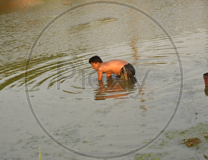 Indian boy taking a bath in the pond
