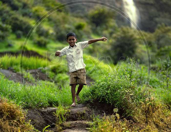 Happy Indian Boy With Waterfall in Background