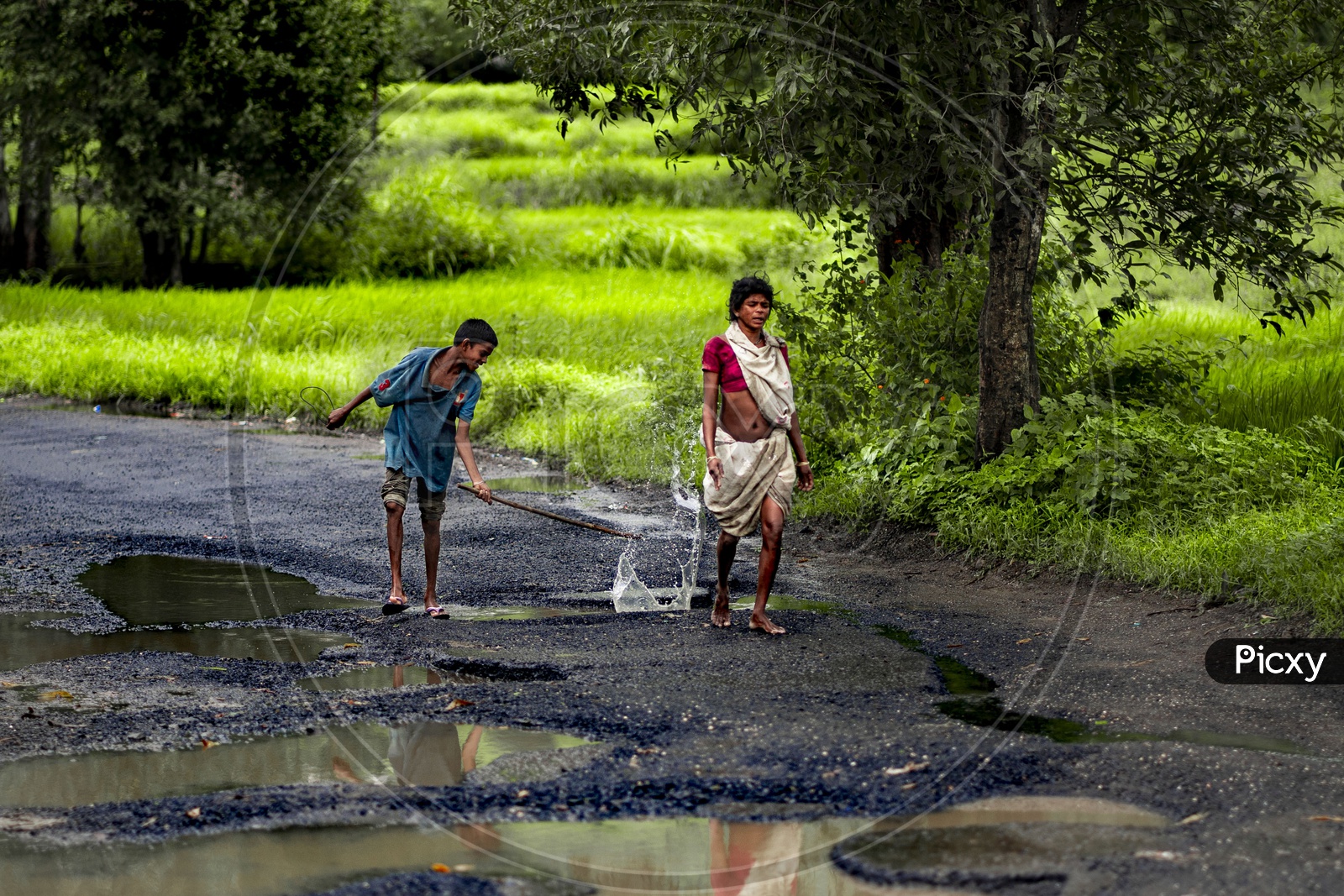 A Boy Splashing WaterPits on Roads  in Rural Vilages