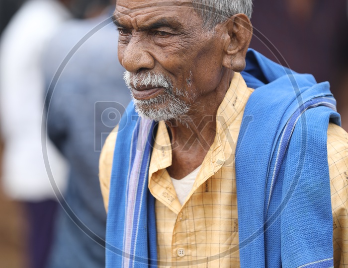Indian Old Man wearing blue towel around his neck