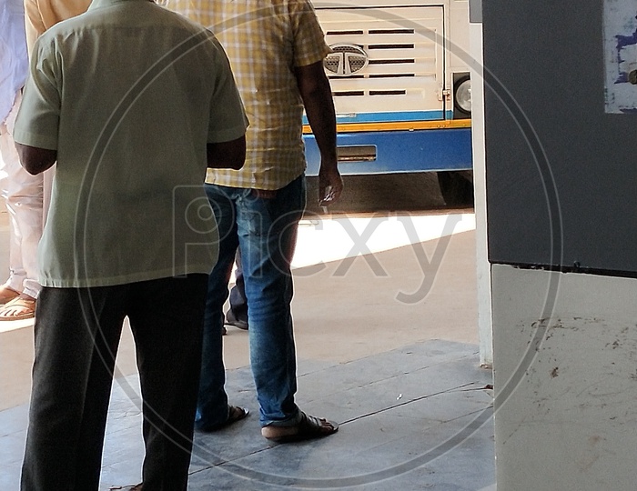 A man smoking cigarette in a bus stand which is a public offence