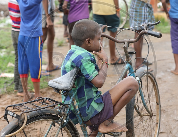 Indian Rural Kid sitting on a bicycle