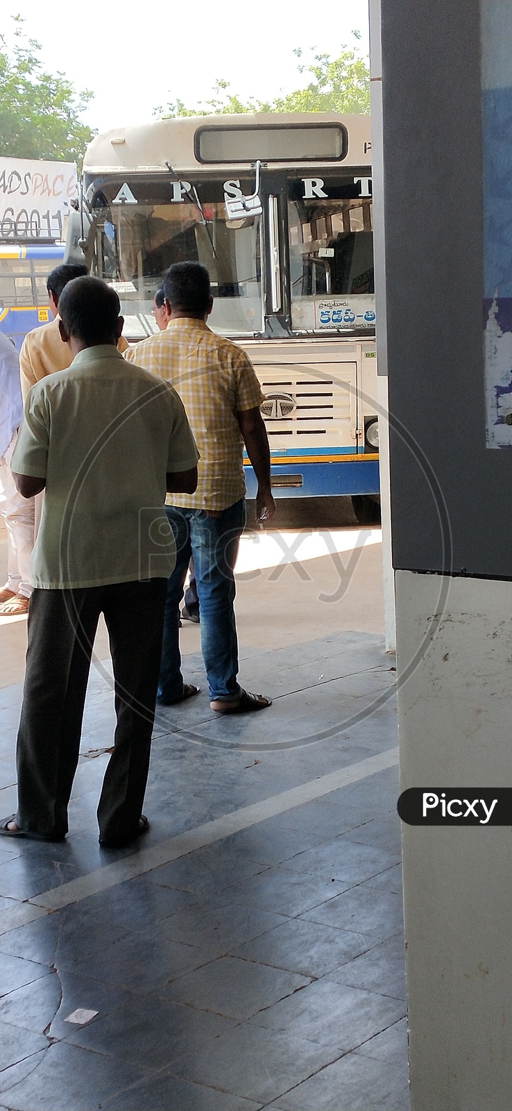 A man smoking cigarette in a bus stand which is a public offence