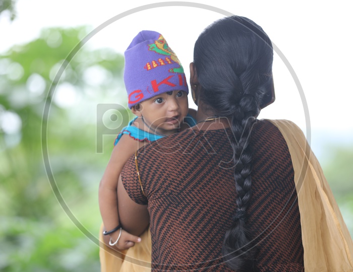 Indian Mother carrying her little girl child on her shoulders