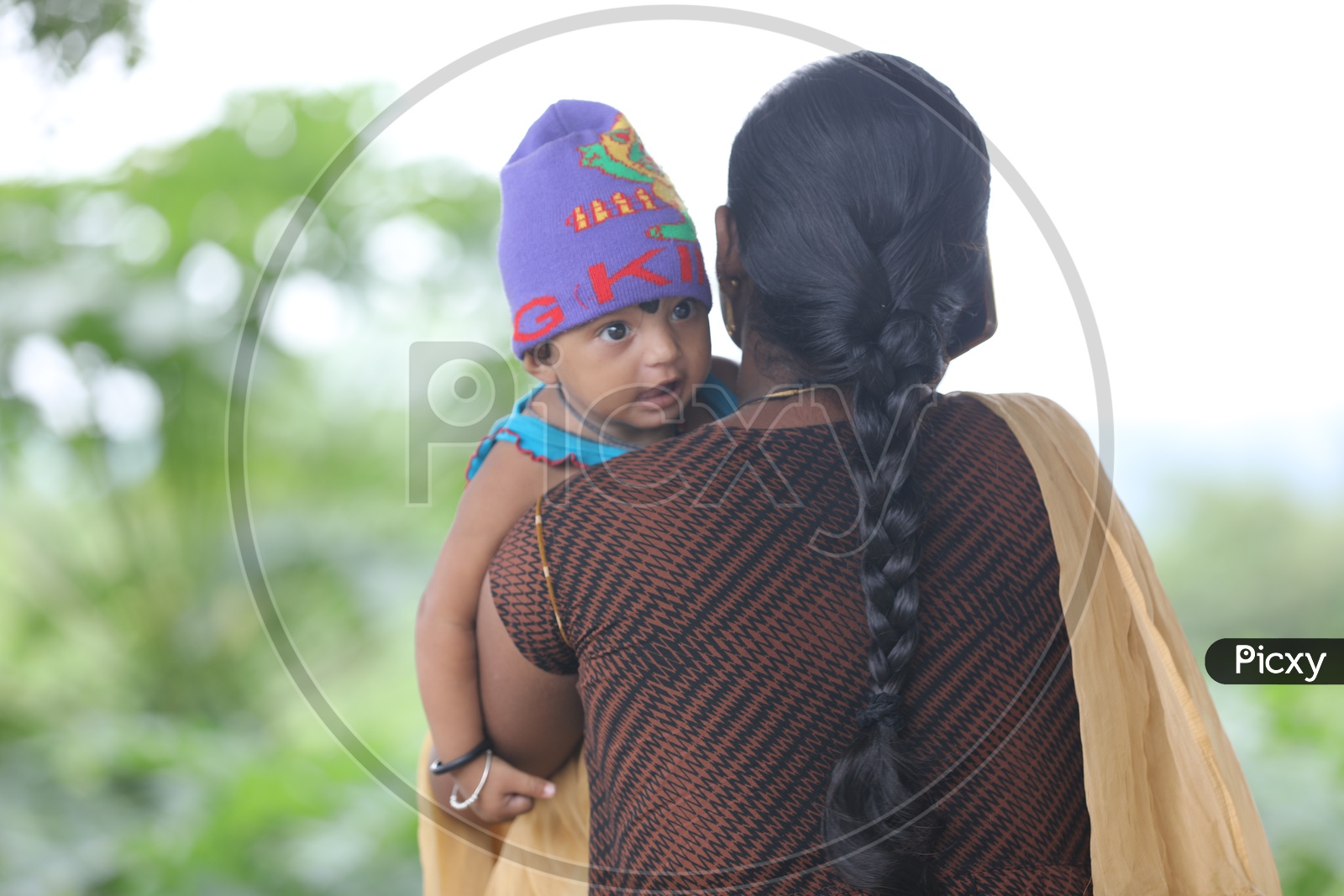 Indian Mother carrying her little girl child on her shoulders