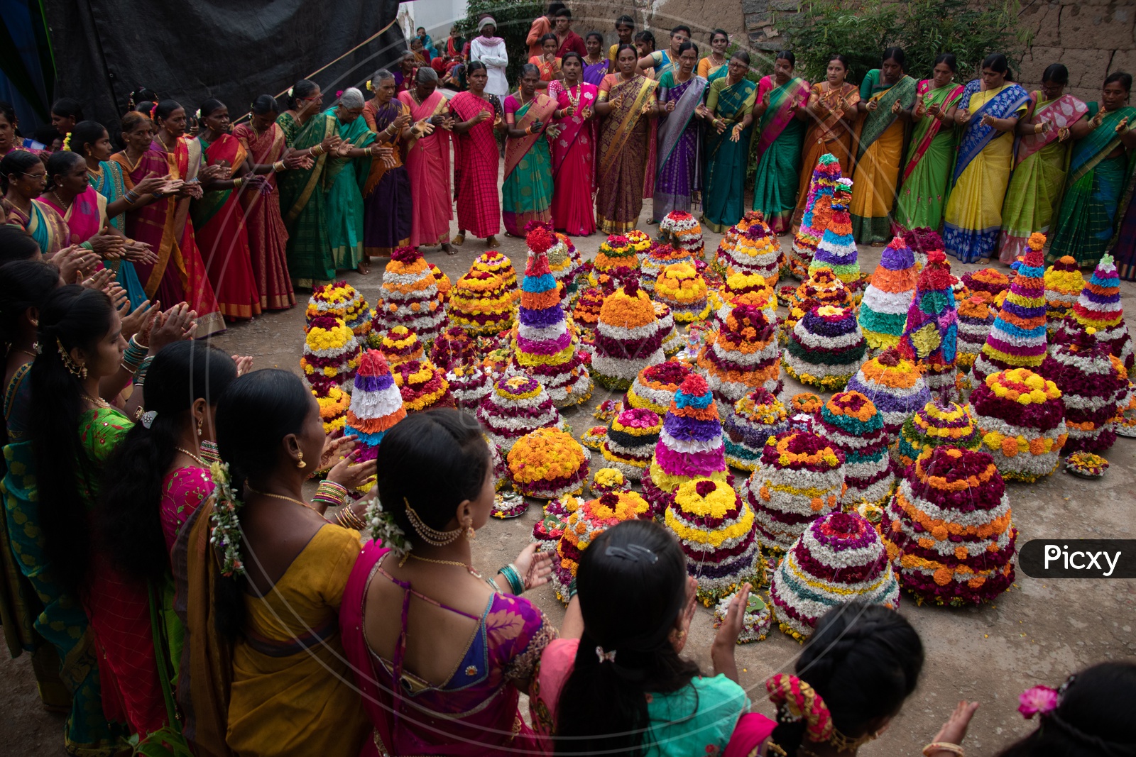 Telangana Woman Celebrating Saddula Bathukamma Festival By Singing Songs Around Floral  Placed In Middle At Rural Telangana Villages