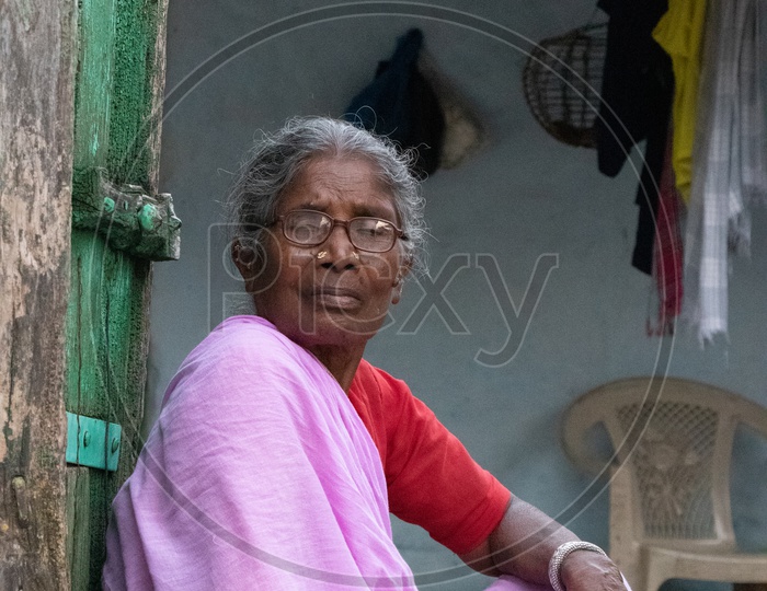 Grandmother Or An Old Woman Sitting At a House Door Step In an Indian Rural Village