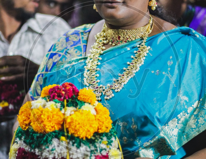 Woman posing with her Bathukamma.