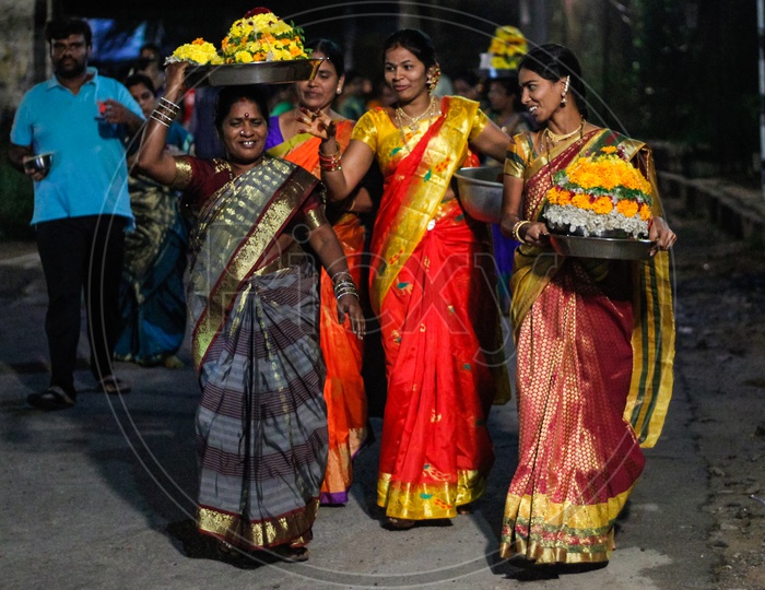 Women walking with their Bathukammas.