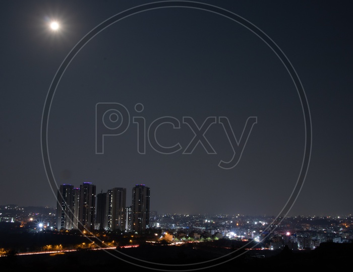 Bright Moon In Sky Over City Scape  With Lanco Hills  Buildings  From Kajaguda Hills