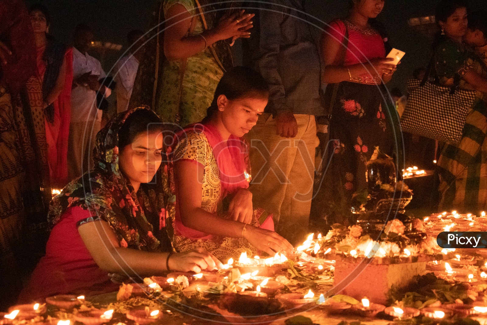 Hindu Devotees offering Prayers To Lord Shiva By Lighting Dias At Koti Deeposthavam Event in Hyderabad