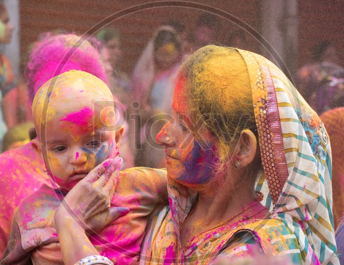 Indian Mother Celebrating Holi With Her Child Filled in Colors