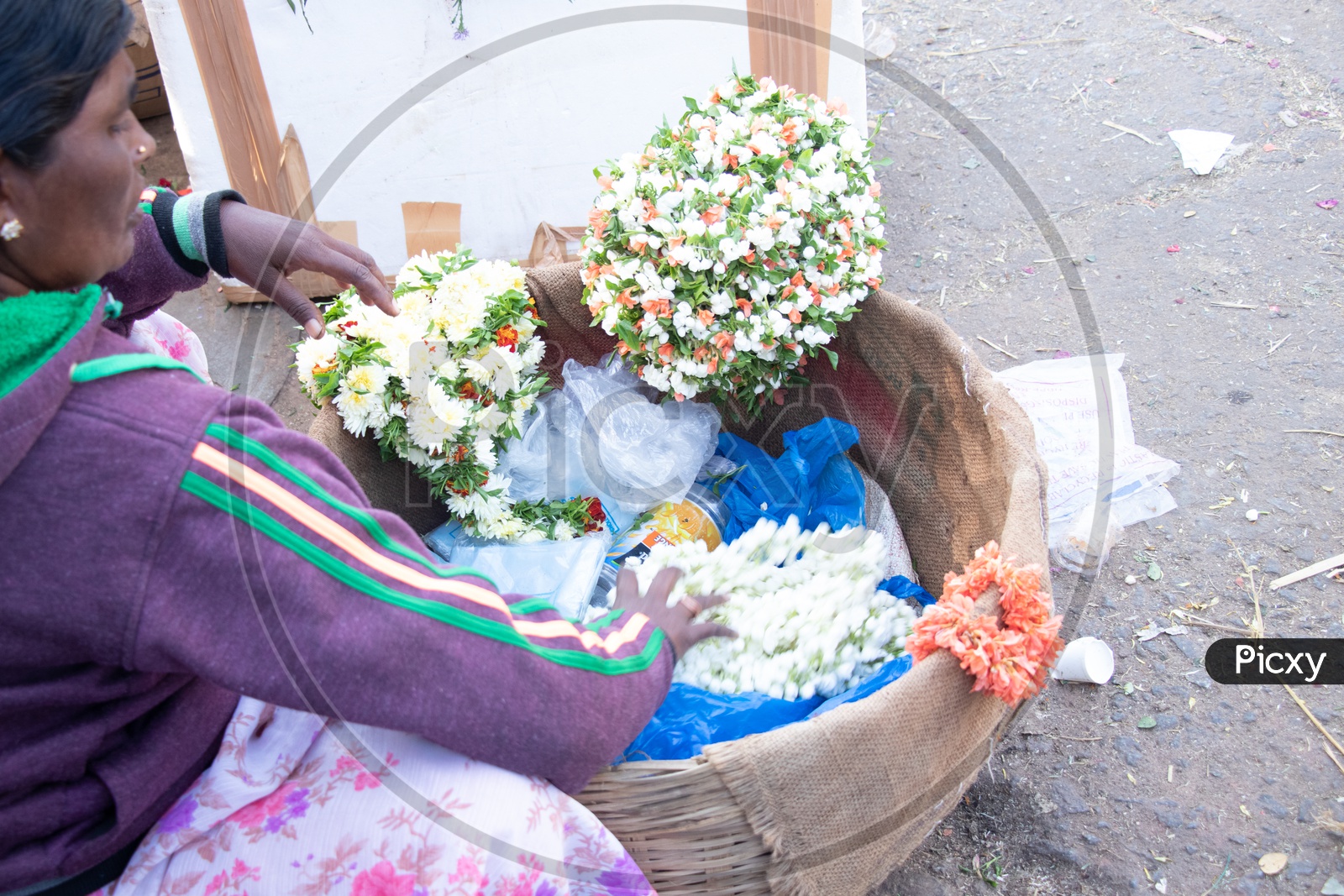 Woman Vendor With Flower Garlands Basket At a Flower Market