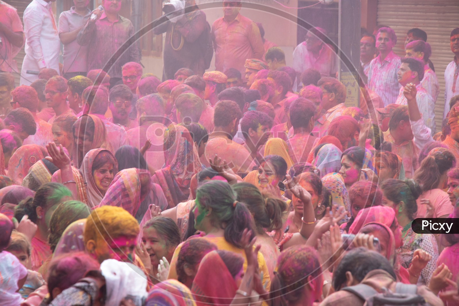 Crowd Of Unidentified Indian People Celebrating Holi Festival by Filling In Colors