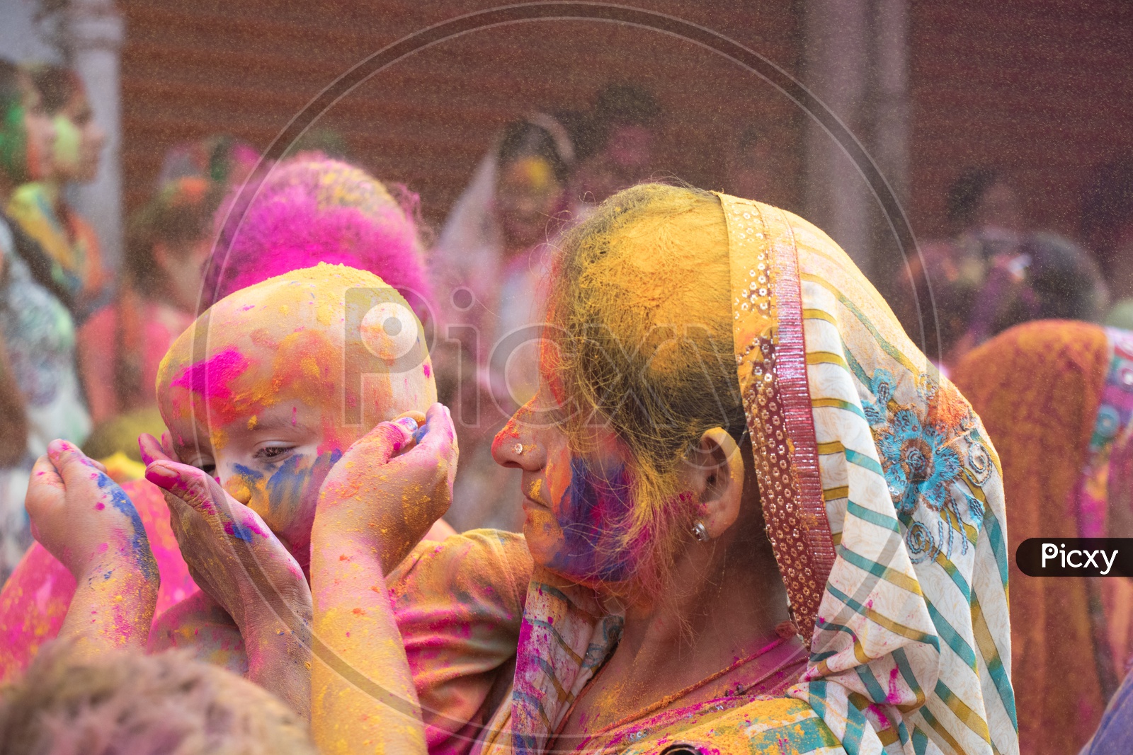 Indian Mother Celebrating Holi With Her Child Filled in Colors