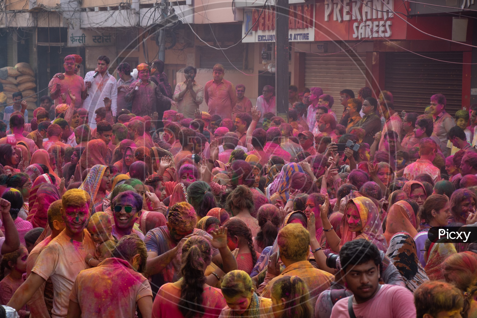 Crowd Of Unidentified Indian People Celebrating Holi Festival by Filling In Colors