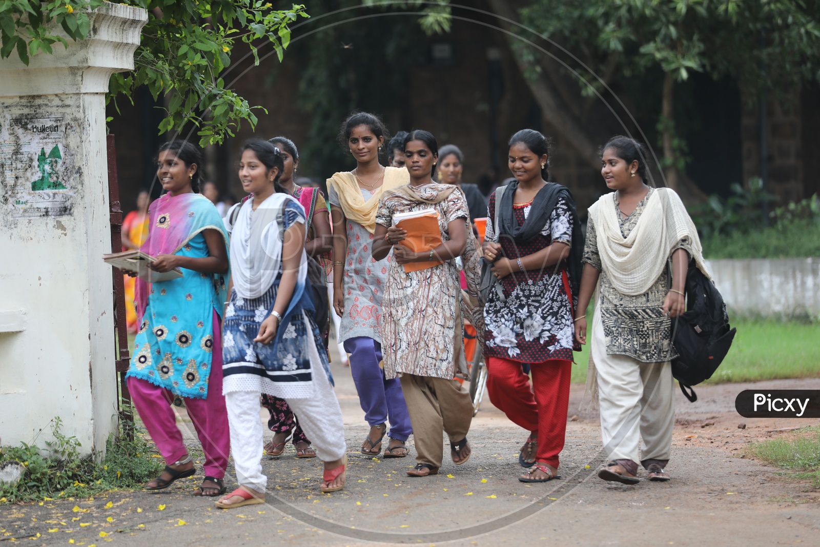 Indian group of college girls walking holding their books