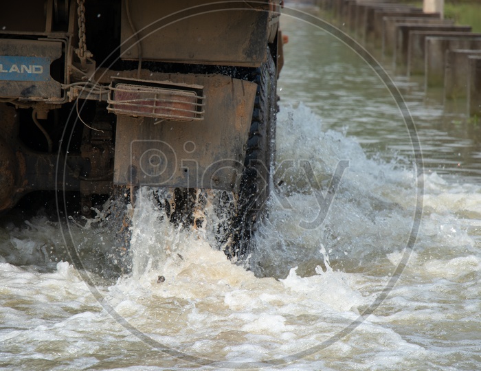 Truck  Tyre Closeup With Water Splash Crossing The Flooded Bridge