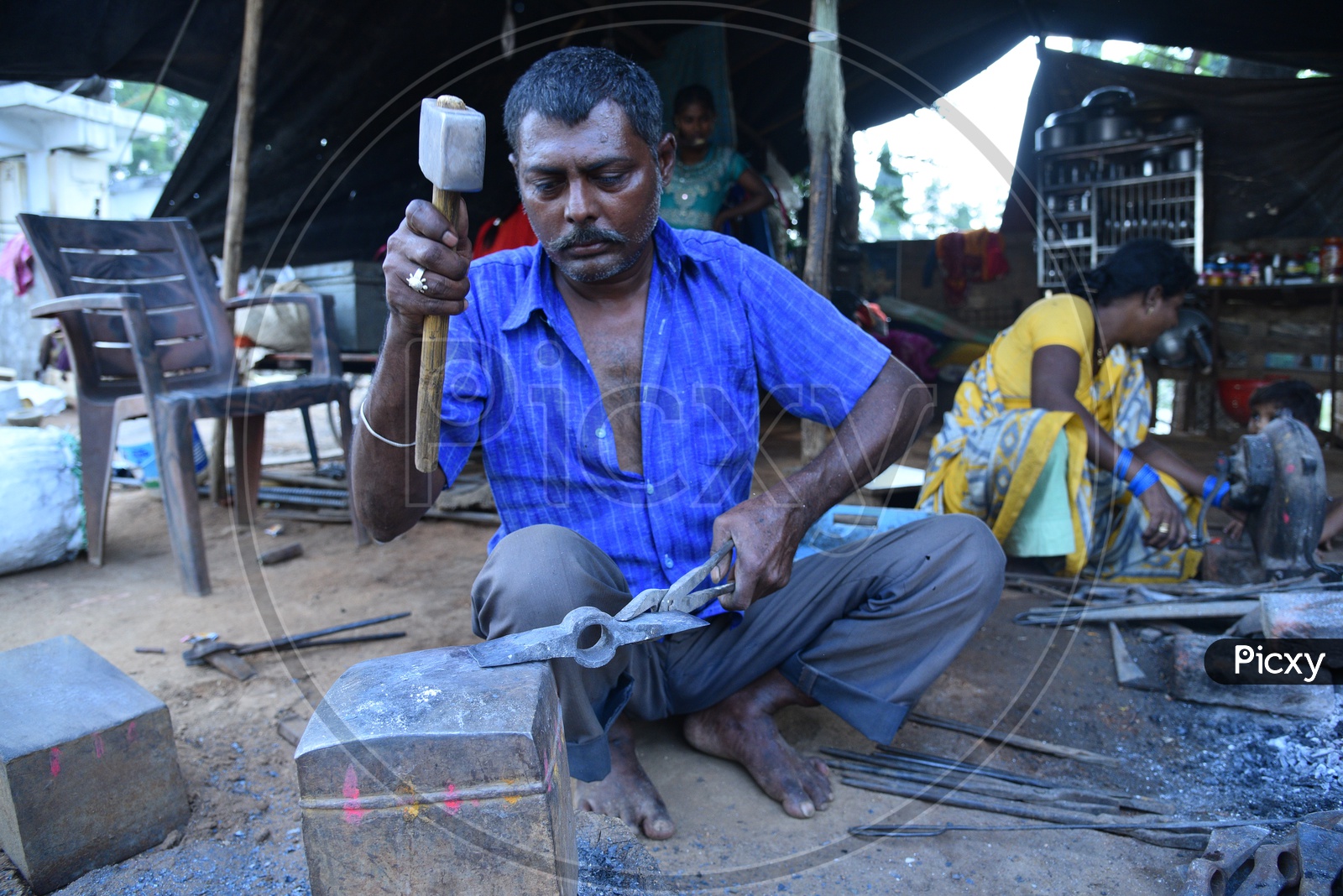 A Blacksmith Shaping the Iron Piece using Hammer
