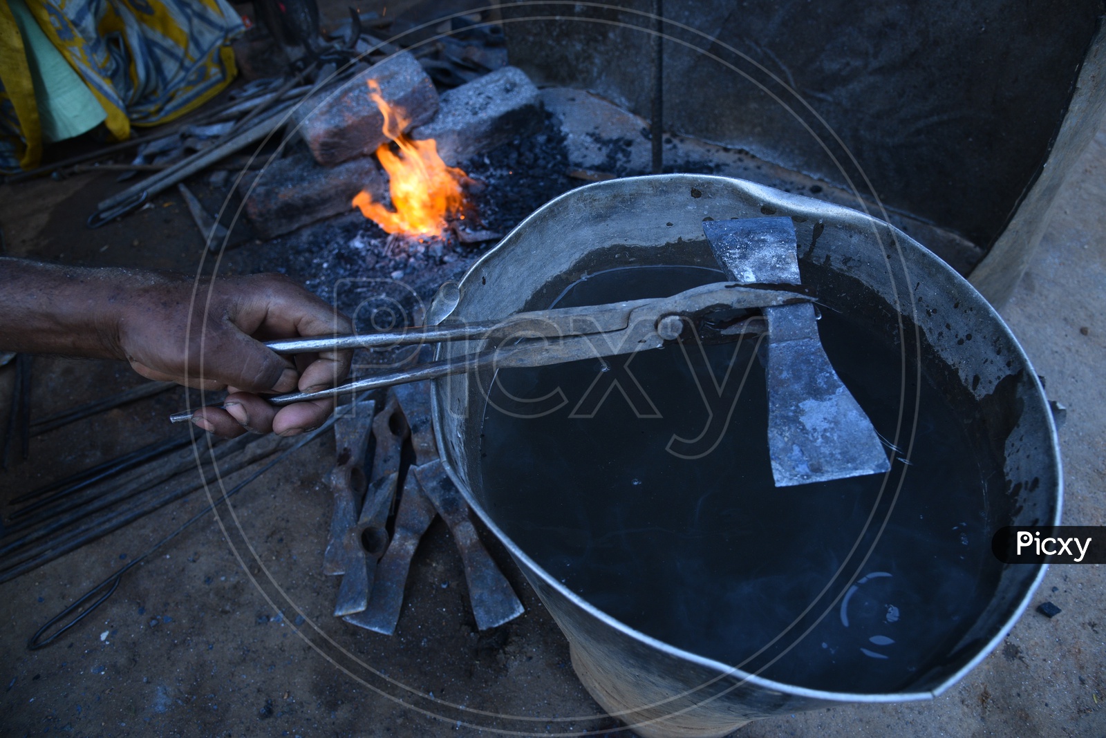 Blacksmith Cooling Hot Metal in Water