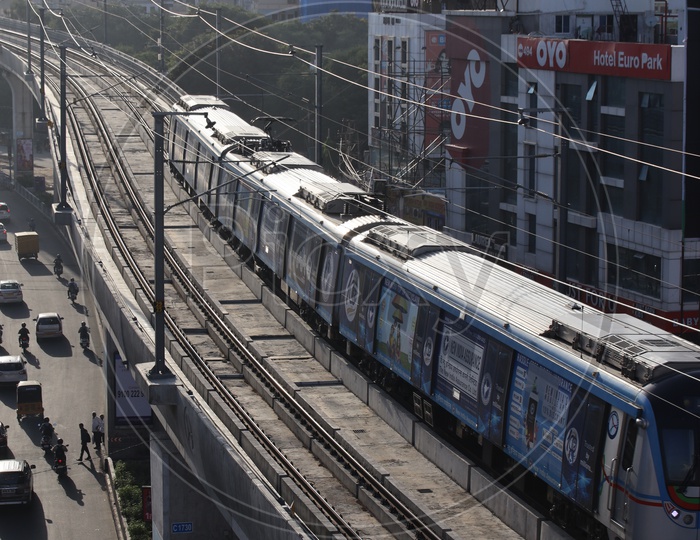 Hyderabad Metro Train Running on Railway  Track Lines With Commuting Vehicles On Roads Composition