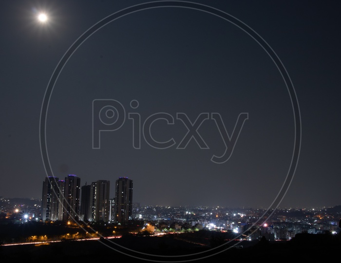 Bright Moon In Sky Over City Scape  With Lanco Hills  Buildings  From Kajaguda Hills