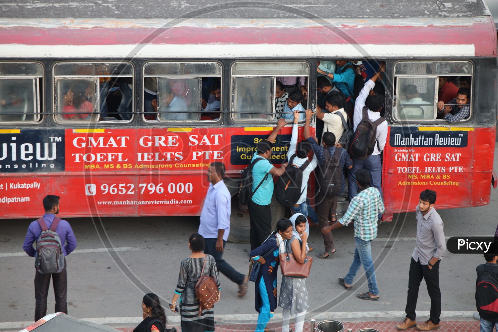 Commuters Boarding A Running Bus And Foot Board  Travelling  In Hyderabad City