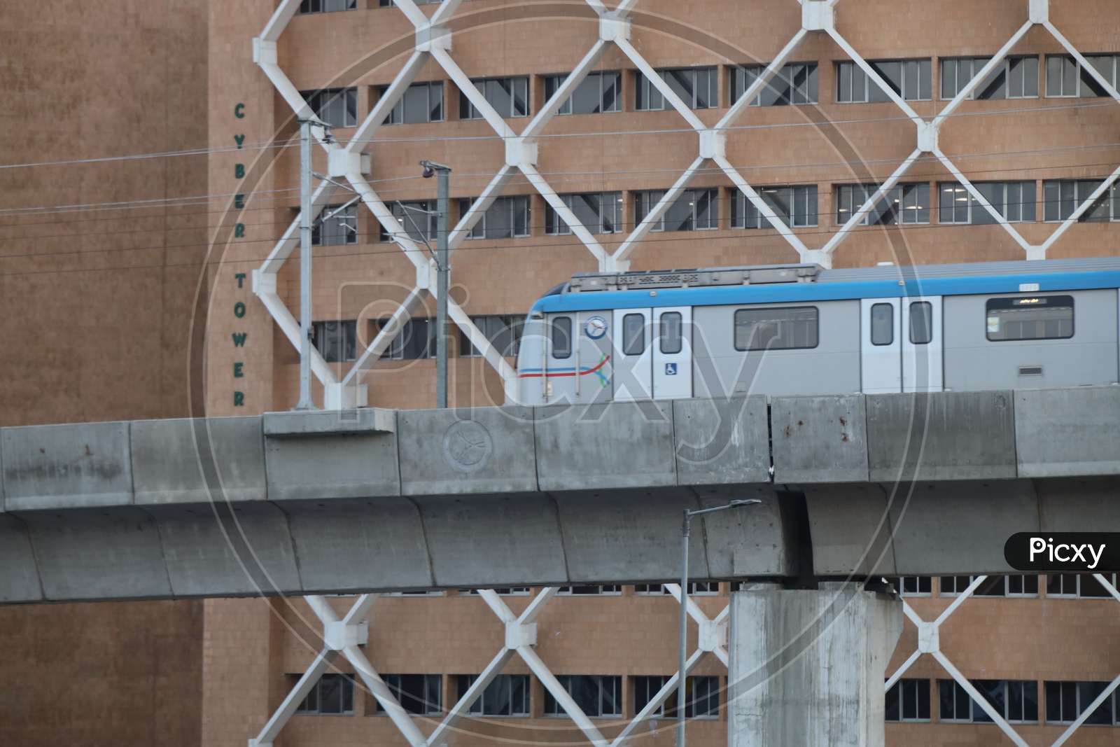 Hyderabad Metro Train Running on Track Line With Cyber Towers in Background