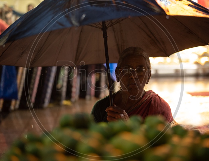 Old Woman Selling Lemons while raining