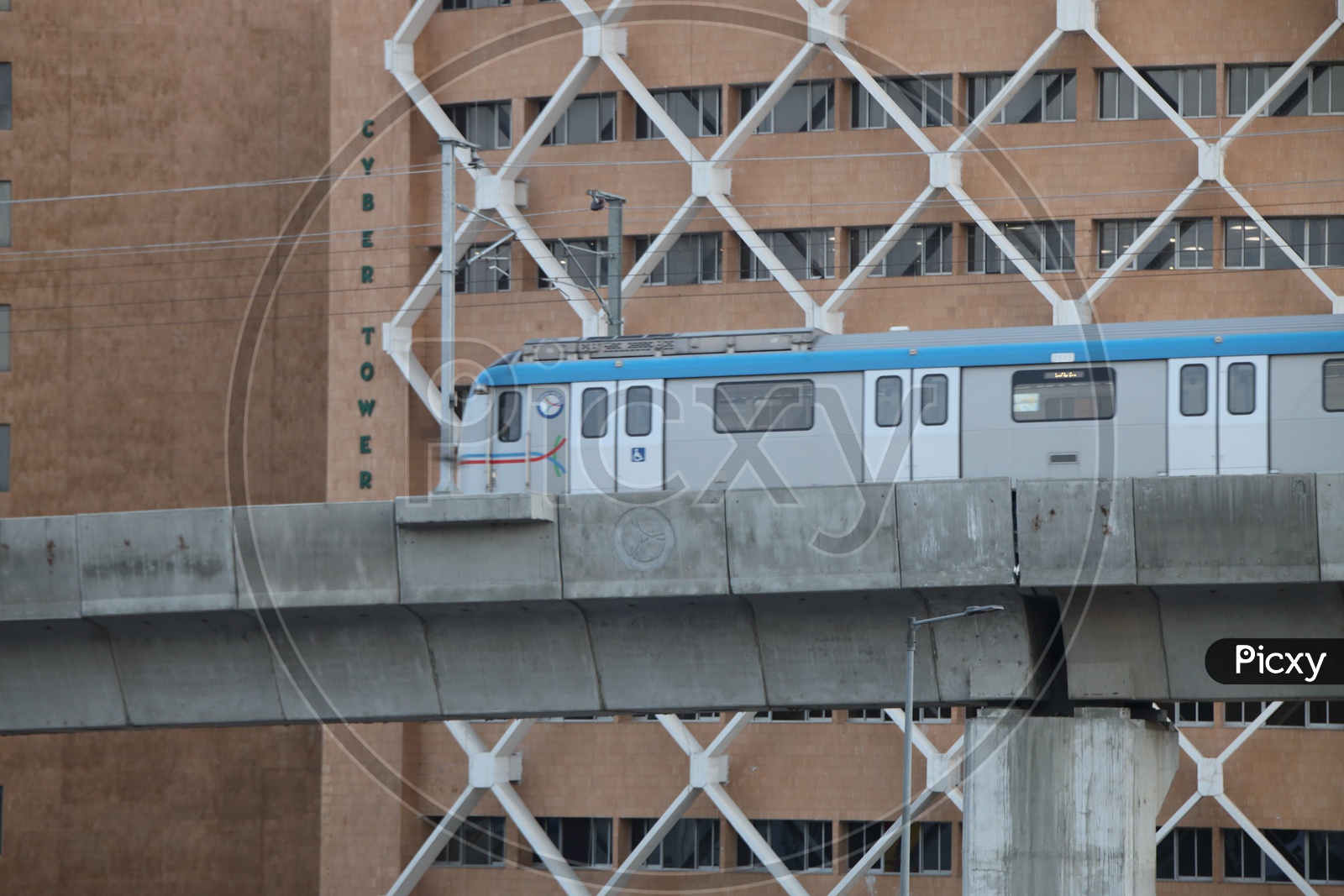 Hyderabad Metro Train Running on Track Line With Cyber Towers in Background