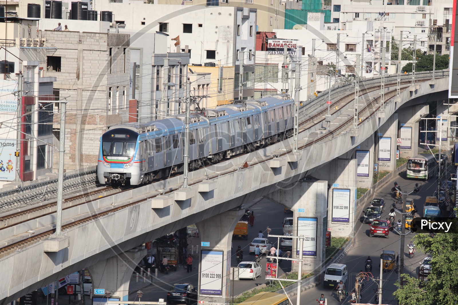 Image of Hyderabad Metro Train Running on Railway Track Lines With Commuting Vehicles On Roads