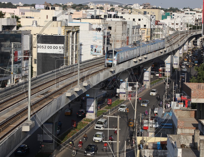 Hyderabad Metro Train Running on Railway  Track Lines With Commuting Vehicles On Roads Composition