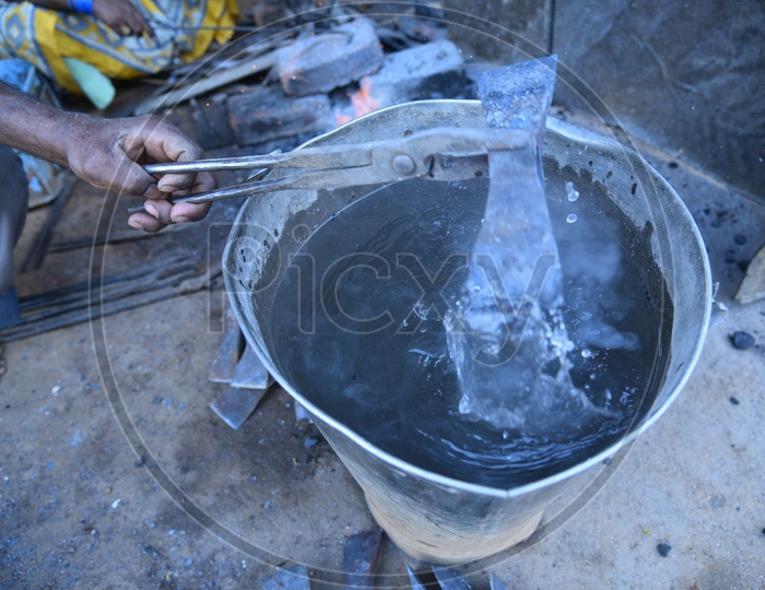 Indian Blacksmith Cooling the Hot Metal in Water