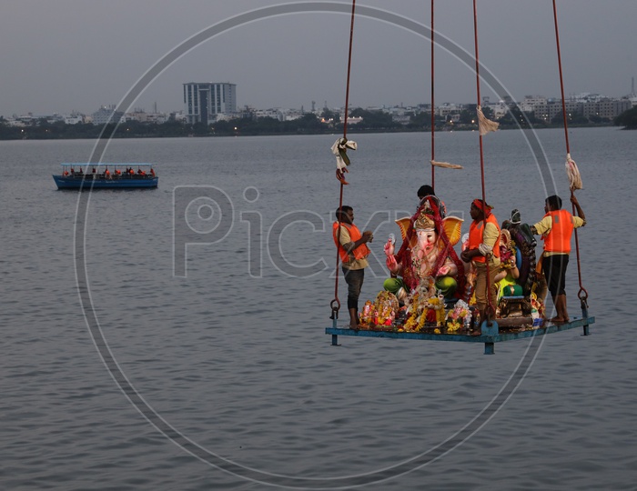 GHMC Workers Carrying Lord Ganesh Idols In Crane For Immersion In Hussain Sagar Lake  During Ganesh Visarjan or Nimarjan Event At Tank Bund