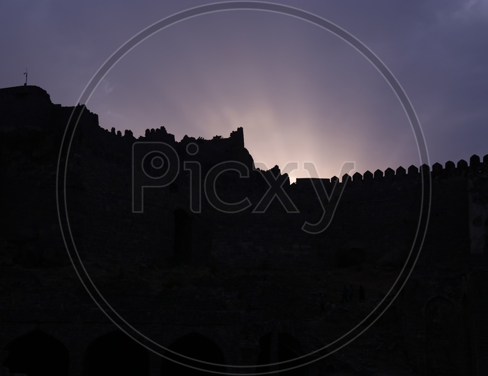 Silhouette of Golconda Fort Canopy Over Sunset Sky Background