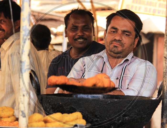 A Street Food Vendor Making Snacks At a Street Food Stall