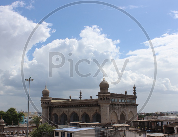 Mecca Masjid With Blue Sky And Cotton Clouds In Background