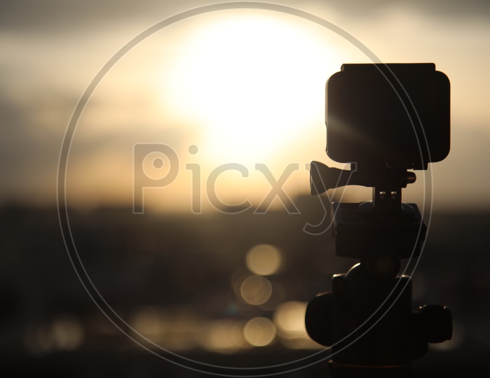 Silhouette  Go Pro Action Camera Mounted to a Tripod  With Sunset Sky Background