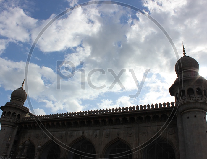 Mecca Masjid With Blue Sky And Cotton Clouds In Background