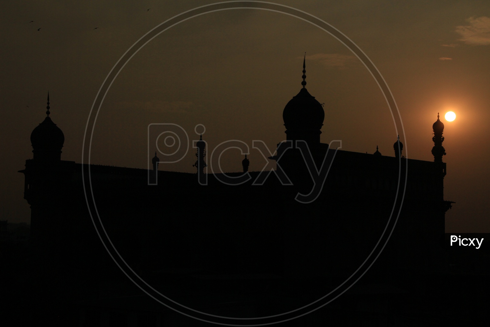 Silhouette Of Mecca masjid With Golden Hour Sunset Sky in Background