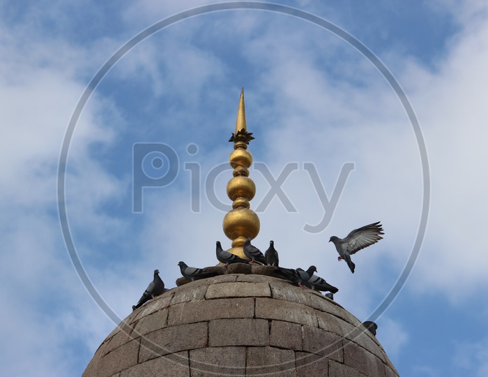 Mecca Masjid Dome With Pigeons With Sky in Background