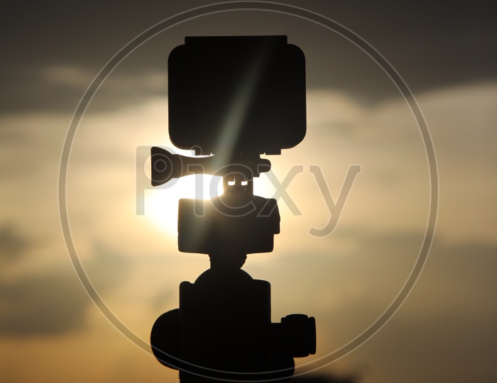 Silhouette  Go Pro Action Camera Mounted to a Tripod  With Sunset Sky Background