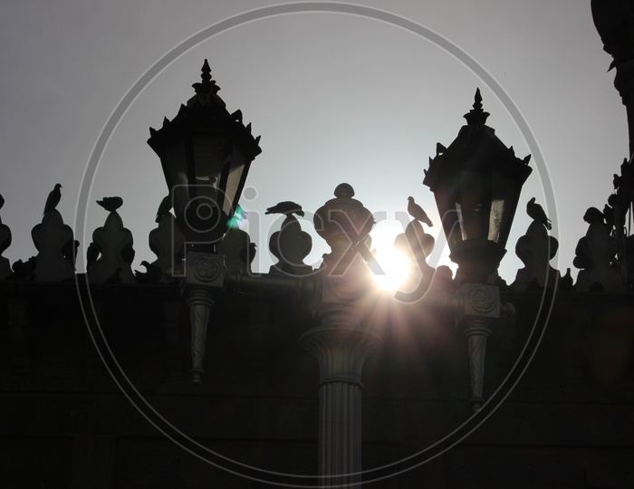 Silhouette Of Pigeons Sitting On Mecca Masjid Terrace And Sky As Background