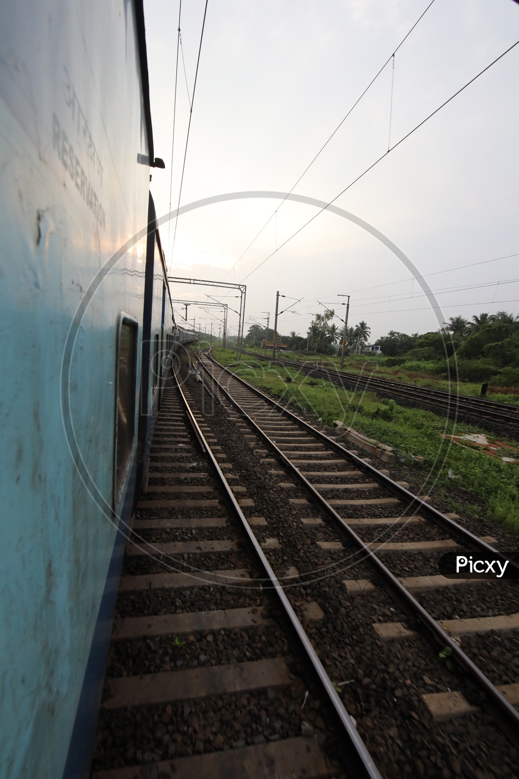 Indian Railways Train Running On Track Lines With Electric Poles and Wire Lines