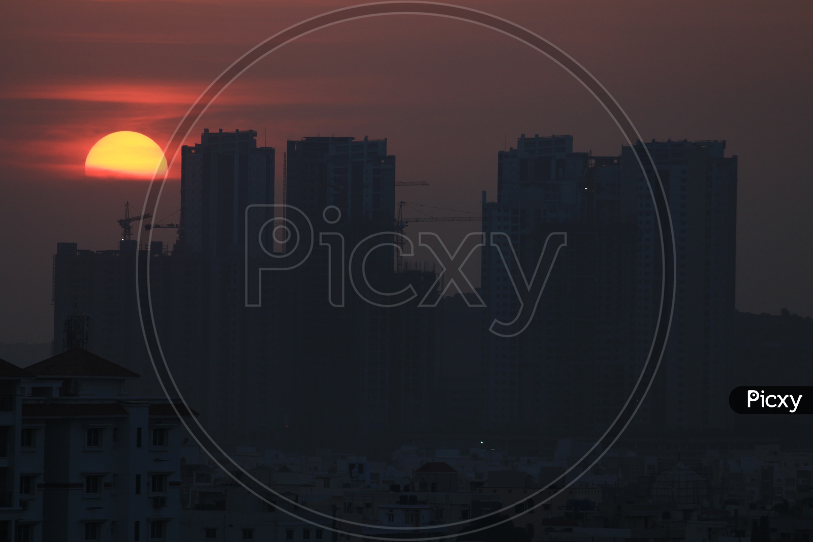 Sunset Over High Rise Buildings Scape With Bright Sun As Background