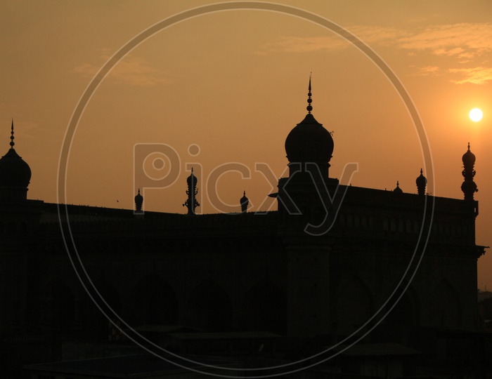 Silhouette Of Mecca masjid With Golden Hour Sunset Sky in Background