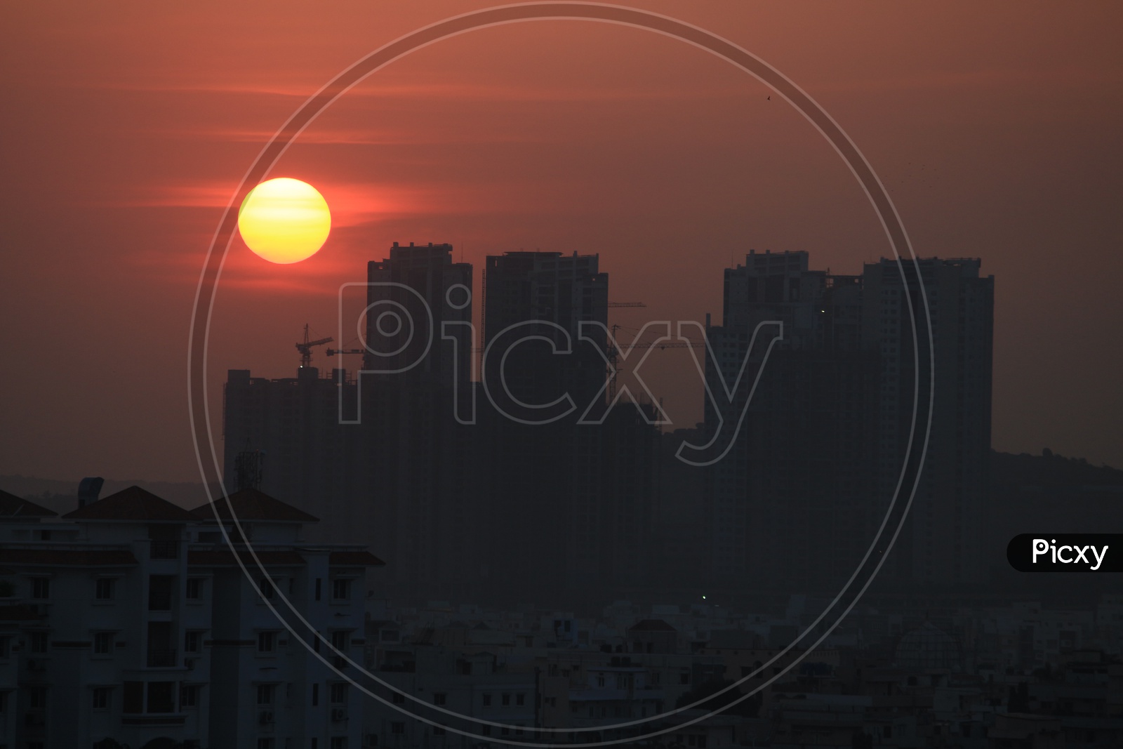 Sunset Over High Rise Buildings Scape With Bright Sun As Background