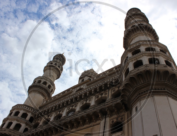 Majestic Charminar With Pillars Composition Over Blue Sky With Cotton Clouds Background