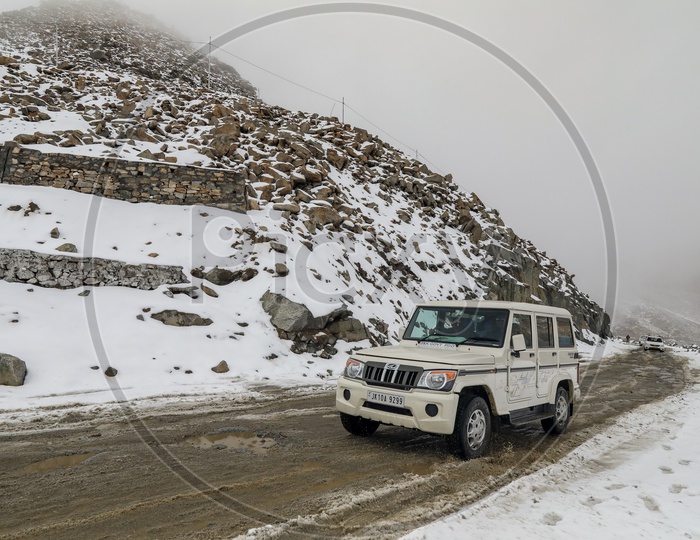 XUV Car in The Roads At Snow Capped Mountains At Ladakh